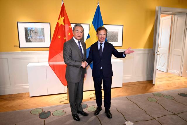 China's Foreign Minister Wang Yi is welcomed by Sweden's Prime Minister Ulf Kristersson for a bilateral meeting at the government headquarters in Stockholm, Sweden on July 4, 2026. (Photo by Jessica GOW / TT News Agency / AFP) / Sweden OUT