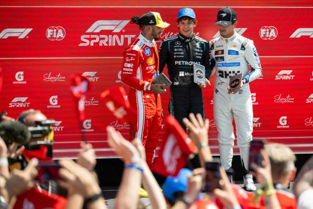 Winner Mercedes' Italian driver Kimi Antonelli (C) second place Ferrari's British driver Lewis Hamilton (L) and third place McLaren's British driver Lando Norris (R) pose with their trophies following the sprint race ahead of the Formula One British Grand Prix at the Silverstone motor racing circuit in Silverstone, central England, on July 4, 2026. (Photo by Ben STANSALL / AFP)