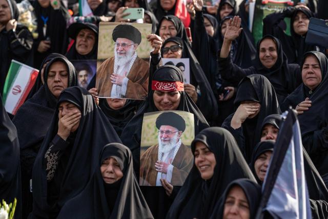 TOPSHOT - Mourners hold portraits of Iran's slain supreme leader Ayatollah Ali Khamenei at the start of his funeral ceremonies at the Grand Mosalla in Tehran on July 4, 2026. Mourners beat their chests and chanted "revenge, revenge" as thousands gathered in Tehran early on July 4 for a final farewell to slain supreme leader Ayatollah Ali Khamenei. Khamenei, who ruled Iran for more than three decades, was killed in US-Israeli attacks in late February that sparked a regional war. (Photo by AFP) / 