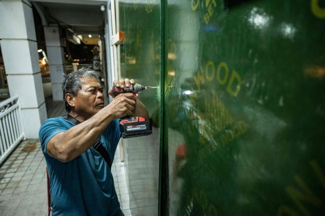 A restaurant worker boards up a restaurant ahead of the arrival of the forecasted Super Typhoon Bavi in Guam, Northern Mariana Islands, on July 4, 2026. People in Guam and the Northern Marianas readied themselves on July 4 as the second "super typhoon" to threaten the US Pacific territories since April drew closer, bringing the equivalent of category-5 hurricane winds. (Photo by Yuichi YAMAZAKI / AFP)
