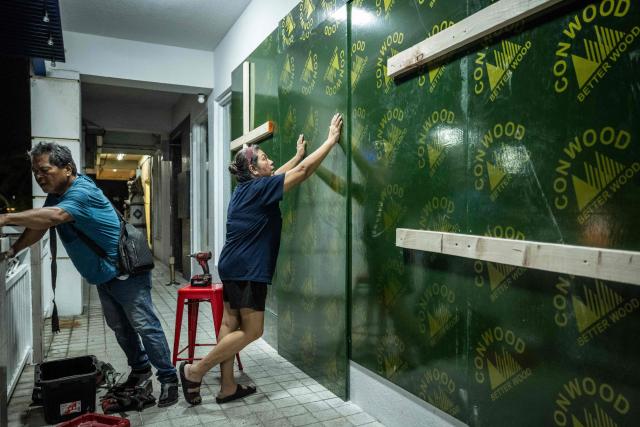 Restaurant workers board up a restaurant ahead of the arrival of the forecasted Super Typhoon Bavi in Guam, Northern Mariana Islands, on July 4, 2026. People in Guam and the Northern Marianas readied themselves on July 4 as the second "super typhoon" to threaten the US Pacific territories since April drew closer, bringing the equivalent of category-5 hurricane winds. (Photo by Yuichi YAMAZAKI / AFP)