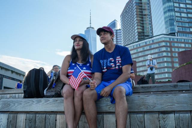 A couple look on from a dock ahead of the "Sail250" ships gathering event, which takes place in the Upper New York Bay and four other ports as the United States celebrates its 250th anniversary on Independence Day, in New York City on July 4, 2026. Millions of Americans celebrate the country's 250th birthday on July 4, 2026, as the landmark celebration comes at a time of deep political division, with a president determined to put his stamp on the festivities. (Photo by Ryan MURPHY / AFP)