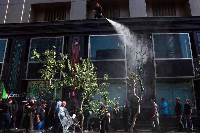 A man sprays water to cool off mourners as they make their way to the Grand Mosalla to pay their final respects to Iran's slain supreme leader Ayatollah Ali Khamenei during his funeral ceremonies in Tehran on July 4, 2026. Vast crowds of Iranians loyal to the Islamic republic massed in Tehran on July 4 to begin almost a week of funeral ceremonies for slain supreme leader Ali Khamenei, which authorities want to send a message of defiance to the West after the war with the United States and Israel. (Photo by AFP) / 