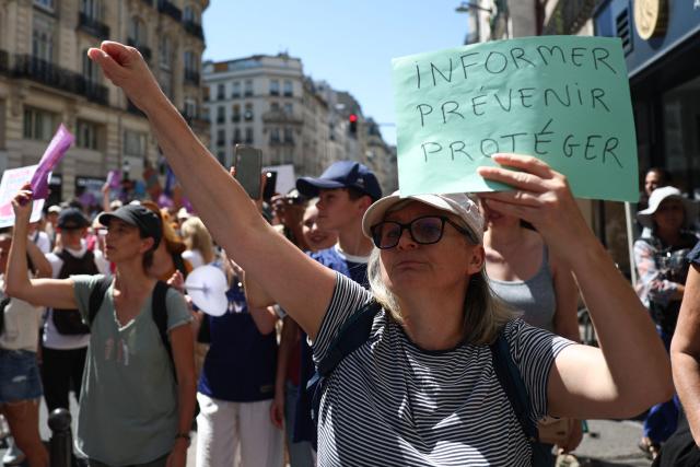 A protester holds a placard reading "Inform, prevent, protect" during a demonstration against sexual violence against women and children, called by the Women's Foundation, at Place de la Bastille central Paris, on July 4, 2026. (Photo by ROMAIN PERROCHEAU / AFP)