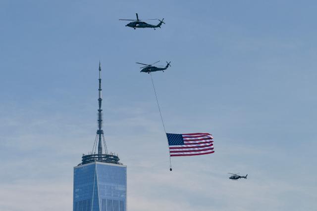 Helicopters fly the American flag past One World Trade Center, Freedom Tower ahead of the Sail4th 250 parade of ships in New York Harbor for the United States 250th anniversary on Independence Day in New York on July 4, 2026. Millions of Americans celebrate the country's 250th birthday on July 4, 2026, as the landmark celebration comes at a time of deep political division, with a president determined to put his stamp on the festivities. (Photo by ANGELA WEISS / AFP)