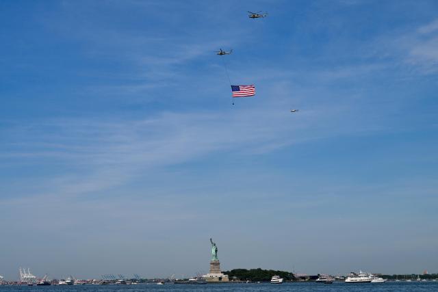 Helicopters fly the American flag past the Statue of Liberty ahead of the Sail4th 250 parade of ships in New York Harbor for the United States 250th anniversary on Independence Day in New York on July 4, 2026. Millions of Americans celebrate the country's 250th birthday on July 4, 2026, as the landmark celebration comes at a time of deep political division, with a president determined to put his stamp on the festivities. (Photo by ANGELA WEISS / AFP)