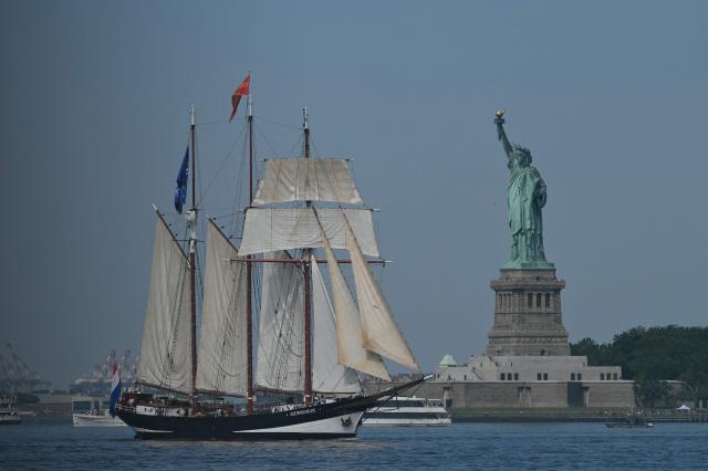 A tall ship sails past the Statue of Liberty during Sail 4th 250 in New York, on July 4, 2026. Millions of Americans celebrated the country's 250th birthday on Saturday -- a landmark celebration that comes at a time of deep political division, with a president determined to put his stamp on the festivities. Washington's traditional fireworks display on the National Mall -- lined with monuments celebrating the nation's Founding Fathers -- has been super-sized, and is being touted as the biggest ever. (Photo by ANGELA WEISS / AFP)