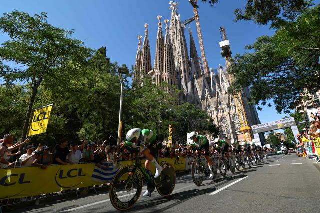 Caja Rural-Seguros RGA team riders cycle past the Sagrada Familia Basilica during the 1st stage of the 113th edition of the Tour de France cycling race, a 19,6 km team time trial stage in and around Barcelona in northeastern Spain, on July 4, 2026. (Photo by Anne-Christine POUJOULAT / AFP)