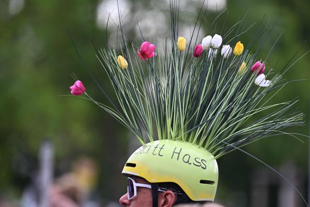 A protester wears a helmet with fake flowers with the lettering "instaed of hatred" during a demonstration in Erfurt, eastern Germany on July 4, 2026, where the party congress of far-right Alternative for Germany (AfD) is held. Thousands of demonstrators flooded a German city on July 4, 2026 blocking major roads and disrupting public transport, in a bid to shut down the annual congress of the far-right AfD party. (Photo by RALF HIRSCHBERGER / AFP)