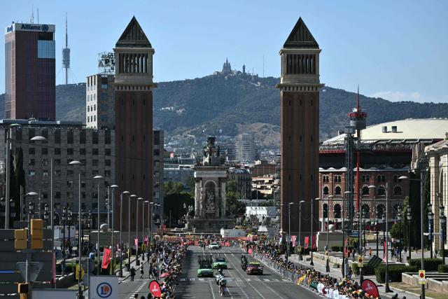 The team Caja Rural-Seguros RGA cycles next to the Venetian Towers at the Plaça d'Espanya during the 1st stage of the 113th edition of the Tour de France cycling race, a 19,6 km team time trial stage in and around Barcelona in northeastern Spain, on July 4, 2026. (Photo by Jeff PACHOUD / AFP)