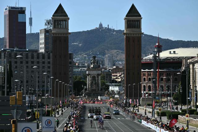 The team Picnic-PostNL cycles next to the Venetian Towers at the Plaça d'Espanya during the 1st stage of the 113th edition of the Tour de France cycling race, a 19,6 km team time trial stage in and around Barcelona in northeastern Spain, on July 4, 2026. (Photo by Jeff PACHOUD / AFP)