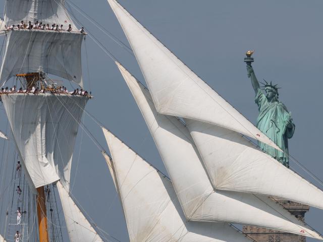 A tall ship sails past the Statue of Liberty during Sail 4th 250 in New York, on July 4, 2026. Millions of Americans celebrated the country's 250th birthday on Saturday -- a landmark celebration that comes at a time of deep political division, with a president determined to put his stamp on the festivities. Washington's traditional fireworks display on the National Mall -- lined with monuments celebrating the nation's Founding Fathers -- has been super-sized, and is being touted as the biggest ever. (Photo by TIMOTHY A. CLARY / AFP)