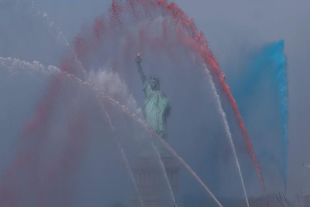 A ship sprays red, white and blue water in front of the Statue of Liberty during Sail 4th 250 in New York, on July 4, 2026. Millions of Americans celebrated the country's 250th birthday on Saturday -- a landmark celebration that comes at a time of deep political division, with a president determined to put his stamp on the festivities. Washington's traditional fireworks display on the National Mall -- lined with monuments celebrating the nation's Founding Fathers -- has been super-sized, and is being touted as the biggest ever. (Photo by TIMOTHY A. CLARY / AFP)