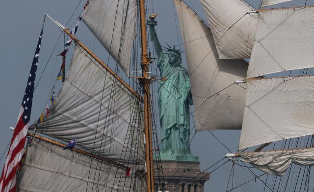 US Coast Guard tall ship Eagle sails past the Statue of Liberty during Sail 4th 250 in New York, on July 4, 2026. Millions of Americans celebrated the country's 250th birthday on Saturday -- a landmark celebration that comes at a time of deep political division, with a president determined to put his stamp on the festivities. Washington's traditional fireworks display on the National Mall -- lined with monuments celebrating the nation's Founding Fathers -- has been super-sized, and is being touted as the biggest ever. (Photo by TIMOTHY A. CLARY / AFP)