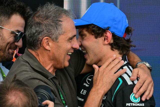 Mercedes' Italian driver Kimi Antonelli (R) celebrates with his father Marco (C) after taking pole position in the qualifying session ahead of the Formula One British Grand Prix at the Silverstone motor racing circuit in Silverstone, central England, on July 4, 2026. (Photo by Andrej ISAKOVIC / AFP)
