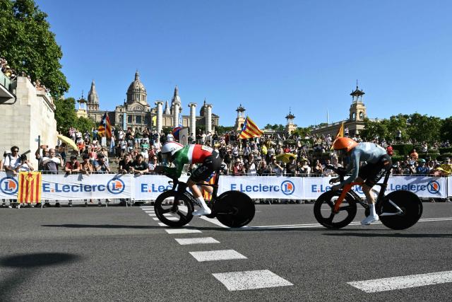 Netcompany INEOS team's Italian rider Filippo Ganna (L) cycles with his team next to the Palau nacional ('National Palace')  on the hill of Montjuic during the 1st stage of the 113th edition of the Tour de France cycling race, a 19,6 km team time trial stage in and around Barcelona in northeastern Spain, on July 4, 2026. (Photo by Jeff PACHOUD / AFP)