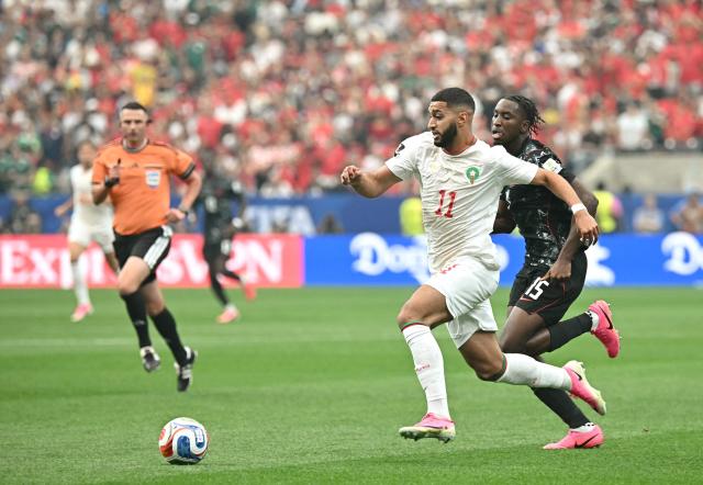 Morocco's midfielder #11 Ismael Saibari runs with the ball past Canada's defender #15 Moise Bombito during the 2026 World Cup round of 16 football match between Canada and Morocco at the Houston Stadium in Houston on July 4, 2026.  (Photo by Paul ELLIS / AFP)