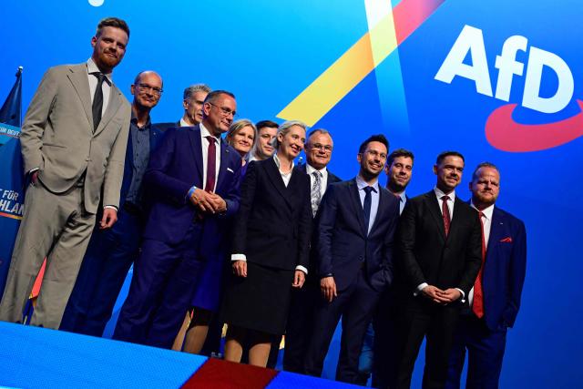 Members of the newly elected federal executive board of the far-right Alternative for Germany (AfD), including party co-leaders Alice Weidel (C) and Tino Chrupalla (3rd L) pose for a group photo at the end of the first day of their party congress at the Messe Erfurt fairground in Erfurt, eastern Germany on July 4, 2026. About 20,000 people flocked to Erfurt, in Thuringia state, according to police, to protest against the Alternative for Germany (AfD) party that tops national opinion polls. (Photo by John MACDOUGALL / AFP)