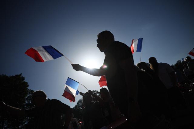 Participants waves French flags during a RN party event "La fete champetre" in Lievin, northern France on July 4, 2026. (Photo by SIMON WOHLFAHRT / AFP)