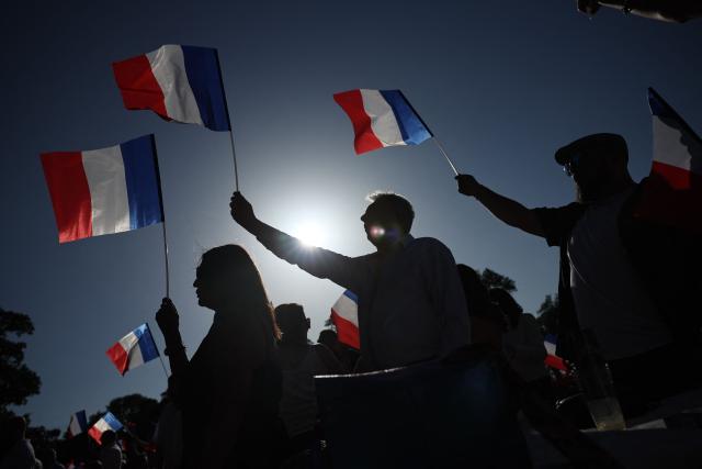 Participants waves French flags during a RN party event "La fete champetre" in Lievin, northern France on July 4, 2026. (Photo by SIMON WOHLFAHRT / AFP)
