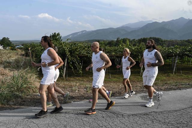 Reenactors dressed as ancient Greeks run with a torch at the foothills of Mount Olympus as part of the four-day Promitheia Festival honouring ancient Greek Gods, near Litochoro, northern Greece, on July 3, 2026. (Photo by Sakis Mitrolidis / AFP)