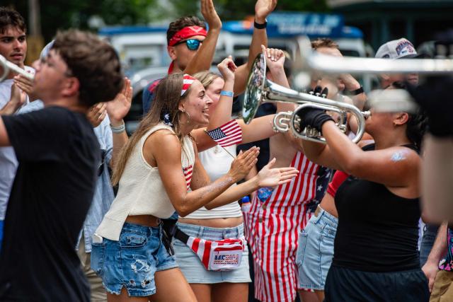 People cheer on a band as they pass by during the 4th of July parade in Bristol, Rhode Island, on July 4, 2026. Millions of Americans celebrated the country's 250th birthday on Saturday -- a landmark celebration that comes at a time of deep political division, with a president determined to put his stamp on the festivities. Washington's traditional fireworks display on the National Mall -- lined with monuments celebrating the nation's Founding Fathers -- has been super-sized, and is being touted as the biggest ever. (Photo by JOSEPH PREZIOSO / AFP)