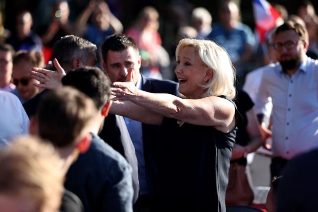 President of Rassemblement National parliamentary group Marine Le Pen (C) reacts as she arrives to attend a RN party event "La fete champetre" in Lievin, northern France on July 4, 2026. (Photo by SIMON WOHLFAHRT / AFP)