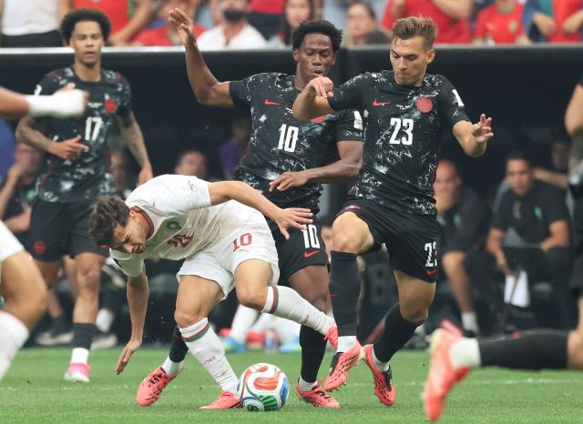 Morocco's forward #10 Brahim Diaz, Canada's forward #10 Jonathan David, and defender #23 Niko Sigur fight for the ball during the 2026 World Cup round of 16 football match between Canada and Morocco at the Houston Stadium in Houston on July 4, 2026.  (Photo by Thomas COEX / AFP)