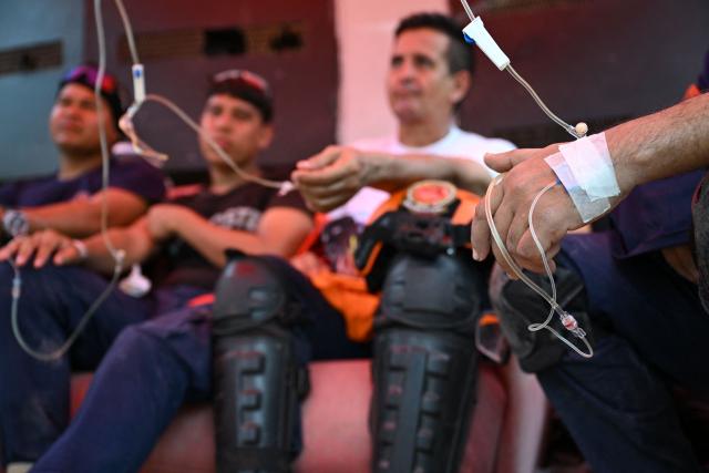 EDITORS NOTE: Graphic content / Volunteers are administered multivitamins intravenously in La Guaira, Venezuela on July 4, 2026, following the June 24 twin earthquakes. With little hope of finding loved ones alive, frustrated families of those affected by Venezuela's double earthquakes clamor for help to recover their loved one's bodies as uncertainty grows over the death toll from the tragedy. (Photo by Raul ARBOLEDA / AFP)
