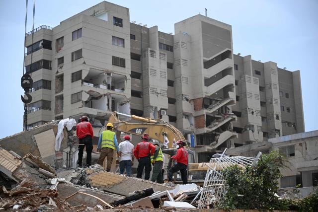 EDITORS NOTE: Graphic content / Rescue workers look for victims at a destroyed building in La Guaira, Venezuela on July 4, 2026, following the June 24 twin earthquakes. With little hope of finding loved ones alive, frustrated families of those affected by Venezuela's double earthquakes clamor for help to recover their loved one's bodies as uncertainty grows over the death toll from the tragedy. (Photo by Raul ARBOLEDA / AFP)