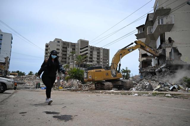 EDITORS NOTE: Graphic content / A backhoe demolishes a building in La Guaira, Venezuela on July 4, 2026, following the June 24 twin earthquakes. With little hope of finding loved ones alive, frustrated families of those affected by Venezuela's double earthquakes clamor for help to recover their loved one's bodies as uncertainty grows over the death toll from the tragedy. (Photo by Raul ARBOLEDA / AFP)