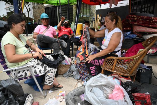 EDITORS NOTE: Graphic content / Survivors fold their clothes after finding them in La Guaira, Venezuela on July 4, 2026, following the June 24 twin earthquakes. With little hope of finding loved ones alive, frustrated families of those affected by Venezuela's double earthquakes clamor for help to recover their loved one's bodies as uncertainty grows over the death toll from the tragedy. (Photo by Raul ARBOLEDA / AFP)