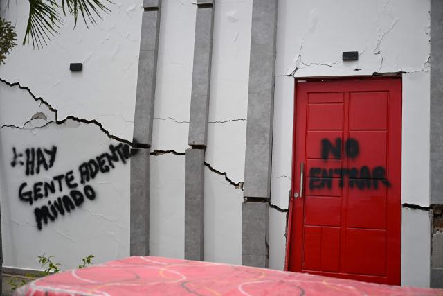EDITORS NOTE: Graphic content / View of a wall reading "There is people inside. Private" and "Do not enter" at a damaged building in La Guaira, Venezuela on July 4, 2026, following the June 24 twin earthquakes. With little hope of finding loved ones alive, frustrated families of those affected by Venezuela's double earthquakes clamor for help to recover their loved one's bodies as uncertainty grows over the death toll from the tragedy. (Photo by Raul ARBOLEDA / AFP)
