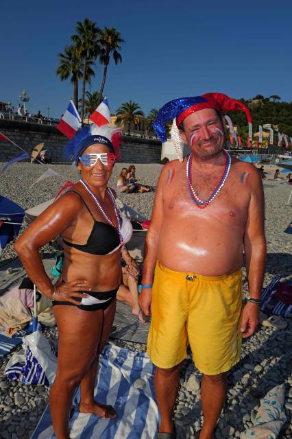 France fans Tina (L) and Thierry (R) pose on the beach ahead of the 2026 World Cup round of 16 football match between Paraguay and France in the French riviera city of Nice, on July 4, 2026. (Photo by Valery HACHE / AFP)