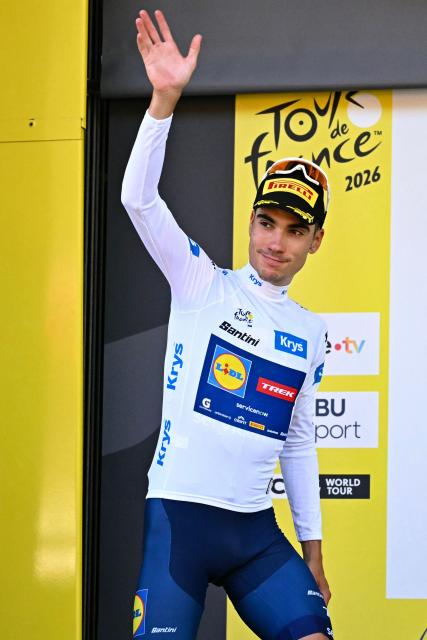 Lidl - Trek team's Spanish rider Juan Ayuso celebrates on the podium with the best young rider's white jersey after the 1st stage of the 113th edition of the Tour de France cycling race, a 19 km team time trial stage in and around Barcelona in northeastern Spain, on July 4, 2026. (Photo by Loic VENANCE / AFP)