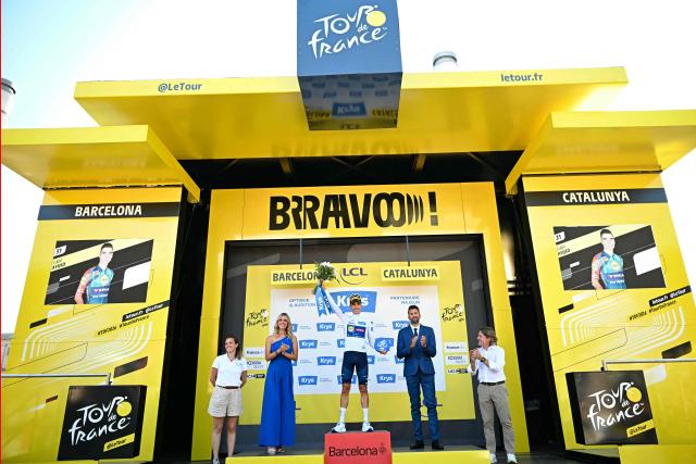 Lidl - Trek team's Spanish rider Juan Ayuso celebrates on the podium with the best young rider's white jersey after the 1st stage of the 113th edition of the Tour de France cycling race, a 19 km team time trial stage in and around Barcelona in northeastern Spain, on July 4, 2026. (Photo by Loic VENANCE / AFP)