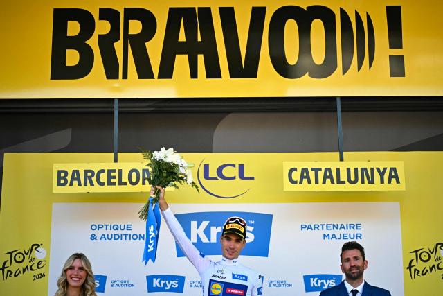 Lidl - Trek team's Spanish rider Juan Ayuso celebrates on the podium with the best young rider's white jersey after the 1st stage of the 113th edition of the Tour de France cycling race, a 19 km team time trial stage in and around Barcelona in northeastern Spain, on July 4, 2026. (Photo by Loic VENANCE / AFP)