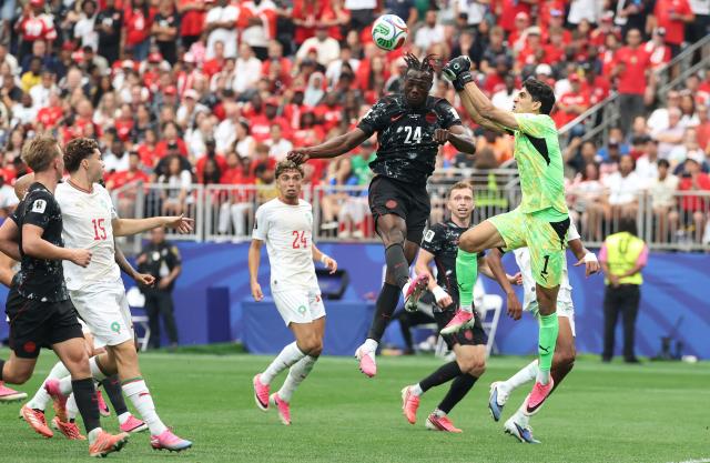 Morocco's goalkeeper #01 Yassine Bounou clears the ball past Canada's forward #24 Promise David during the 2026 World Cup round of 16 football match between Canada and Morocco at the Houston Stadium in Houston on July 4, 2026.  (Photo by Thomas COEX / AFP)