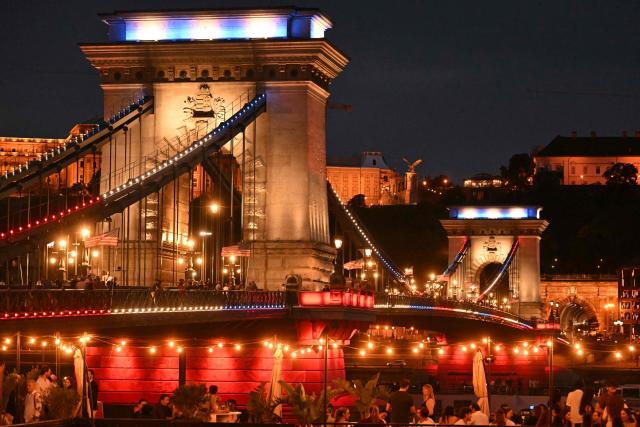 Hungary’s oldest bridge, the Chain Bridge is illuminated in the colors of the United States flag in downtown Budapest on July 4, 2026. The iconic landmark is illuminated in red, white and blue to mark the 250th anniversary of American independence. The special lighting transforms one of Budapest’s most recognizable symbols into a striking tribute spanning the Danube. (Photo by Attila KISBENEDEK / AFP)