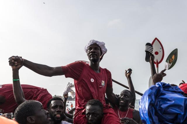 A paddler from the Ouakam neighborhood is lifted after winning one of the races during the annual Ngor Regatta, off the coast of Ngor island, in Dakar, on July 4, 2026. Sailors and fishermen from different communities gathered for the annual Ngor Regatta, a sporting event celebrating the culture and traditions of the Lebou people, a traditional fishing community in Senegal. (Photo by PATRICK MEINHARDT / AFP)