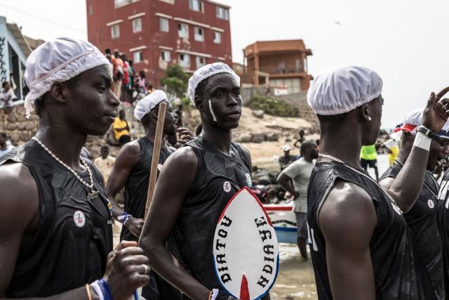 Paddlers from the Xataxely community in Ngor village get ready before the start of the annual Ngor Regatta, off the coast of Ngor island, in Dakar, on July 4, 2026. Sailors and fishermen from different communities gathered for the annual Ngor Regatta, a sporting event celebrating the culture and traditions of the Lebou people, a traditional fishing community in Senegal. (Photo by PATRICK MEINHARDT / AFP)