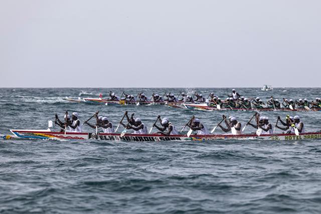 Paddlers from different communities within Ngor Village compete during the annual Ngor Regatta, off the coast of Ngor island, in Dakar, on July 4, 2026. Sailors and fishermen from different communities gathered for the annual Ngor Regatta, a sporting event celebrating the culture and traditions of the Lebou people, a traditional fishing community in Senegal. (Photo by PATRICK MEINHARDT / AFP)