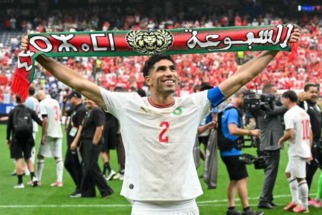 Morocco's defender #02 Achraf Hakimi shows a scarf as he celebrates after winning the 2026 World Cup round of 16 football match between Canada and Morocco at the Houston Stadium in Houston on July 4, 2026.  (Photo by RONALDO SCHEMIDT / AFP)