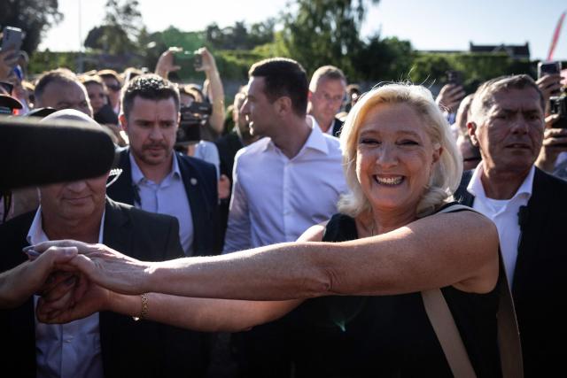 President of Rassemblement National parliamentary group Marine Le Pen shakes hands with a partisan during a RN party event "La fete champetre" in Lievin, northern France on July 4, 2026. (Photo by Simon WOHLFAHRT / AFP)