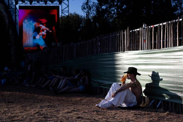 A festivalgoer sits in the evening sunshine during the 36th edition of the Les Eurockeennes de Belfort music festival, in Sermamagny, eastern France, on July 4, 2026. (Photo by ROMEO BOETZLE / AFP)