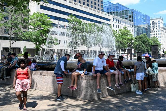 People cool off near a fountain in Freedom Plaza ahead of the "Salute to America" Independence Day celebration in Washington, DC, on July 4, 2026. The nation is marking the 250th anniversary of the United States Declaration of Indpendence. (Photo by Alex WROBLEWSKI / AFP)