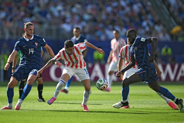 France's midfielder #14 Adrien Rabiot, Paraguay's midfielder #10 Miguel Almiron, and France's defender #04 Dayot Upamecano fight for the ball during the 2026 World Cup round of 16 football match between Paraguay and France at the Philadelphia Stadium in Philadelphia on July 4, 2026.  (Photo by MAURO PIMENTEL / AFP)