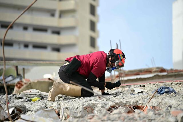 A Venezuelan rescuer searches through the rubble for bodies in Catia La Mar, La Guaira state, Venezuela on July 4, 2026, following the June 24 twin earthquakes. The death toll from Venezuela's devastating twin earthquakes has risen to 2,954, according to official figures released on Saturday. (Photo by MARTIN BERNETTI / AFP)