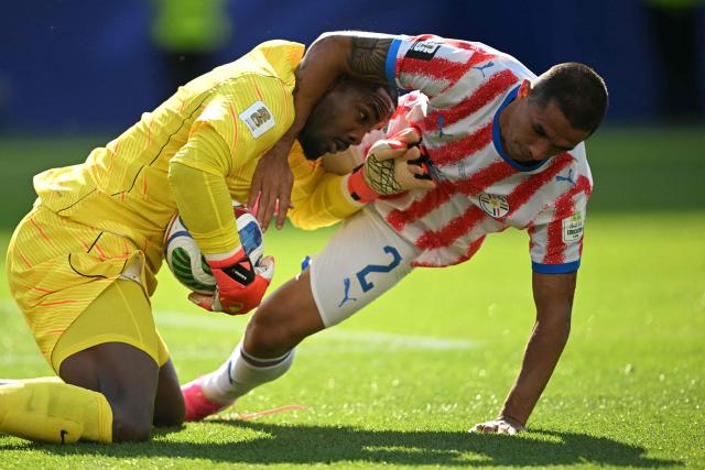 France's goalkeeper #16 Mike Maignan grabs the ball past Paraguay's defender #02 Gustavo Velazquez during the 2026 World Cup round of 16 football match between Paraguay and France at the Philadelphia Stadium in Philadelphia on July 4, 2026.  (Photo by MAURO PIMENTEL / AFP)