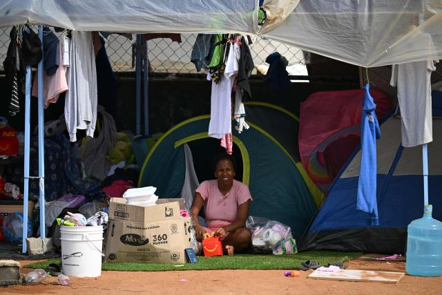 A displaced woman sit outside tents at a makeshift camp in La Guaira, Venezuela on July 4, 2026, following the June 24 twin earthquakes. With little hope of finding loved ones alive, frustrated families of those affected by Venezuela's double earthquakes clamor for help to recover their loved one's bodies as uncertainty grows over the death toll from the tragedy. (Photo by Raul ARBOLEDA / AFP)